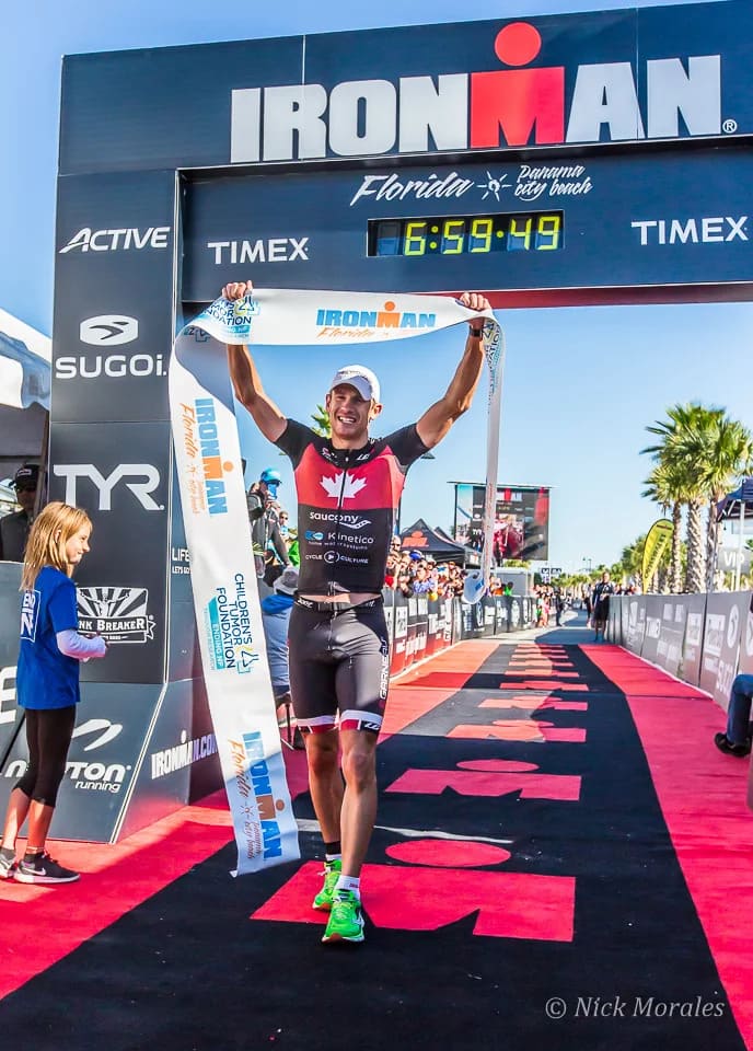 Lionel Sanders levant les bras sur la ligne d'arrivée de l'Ironman de Floride en 2014.